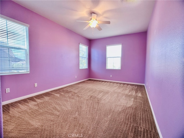 carpeted spare room featuring ceiling fan