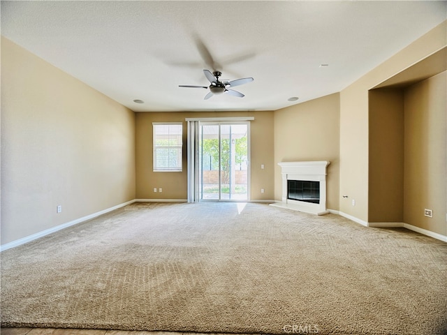 unfurnished living room featuring light carpet and ceiling fan