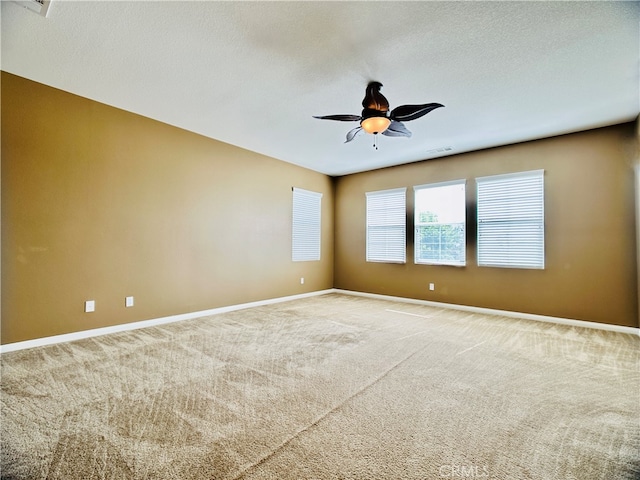 unfurnished room featuring ceiling fan, carpet flooring, and a textured ceiling