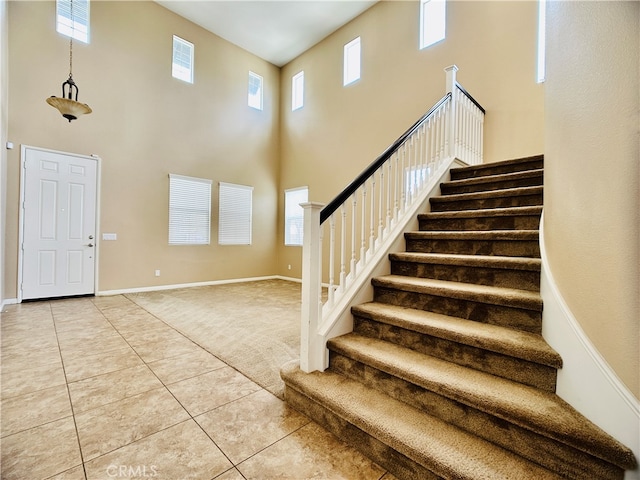 foyer with a high ceiling and tile patterned flooring