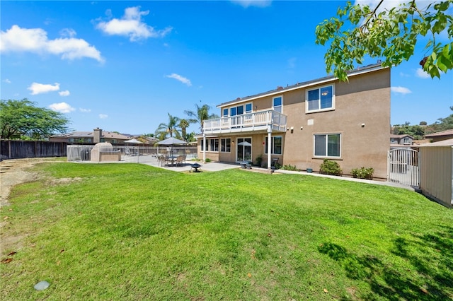 rear view of house with a storage unit, a lawn, and a patio area