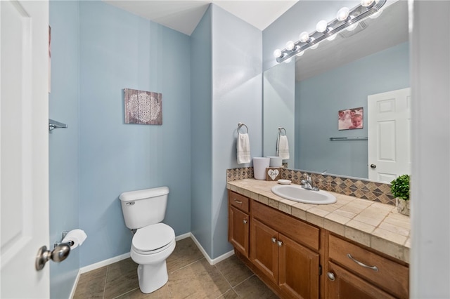 bathroom with vanity, tile patterned flooring, and toilet