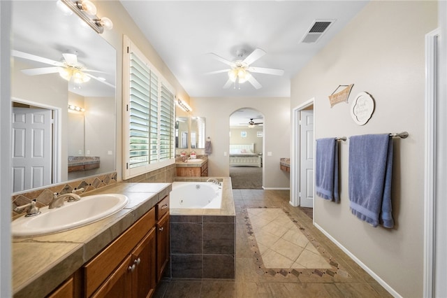 bathroom featuring tile patterned floors, vanity, and tiled bath