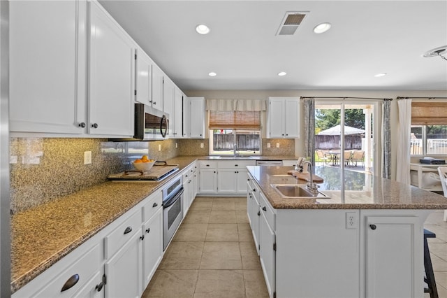 kitchen with a kitchen island with sink, appliances with stainless steel finishes, sink, and white cabinetry