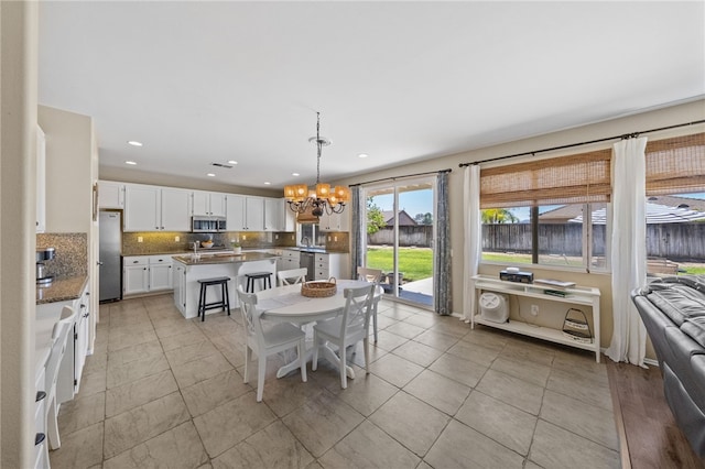 tiled dining area with a notable chandelier and sink