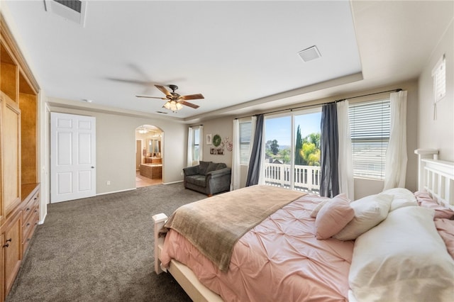 bedroom featuring ceiling fan, ensuite bath, dark colored carpet, and access to outside