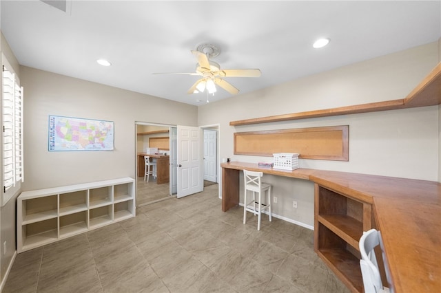 office area with ceiling fan and built in desk