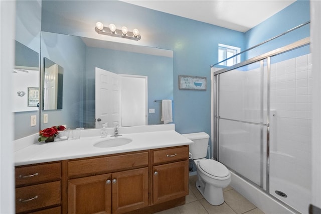 bathroom featuring vanity, tile patterned flooring, toilet, and a shower with door