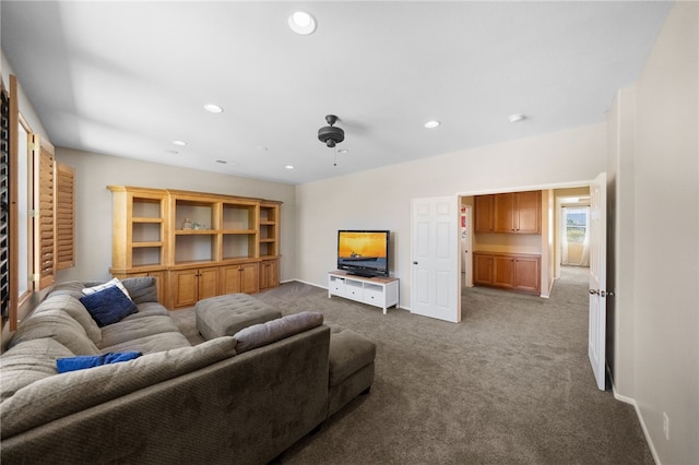 carpeted living room with ceiling fan