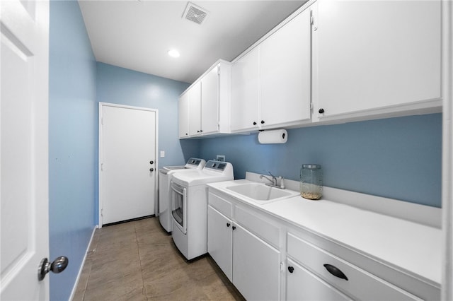 laundry room with independent washer and dryer, cabinets, and sink