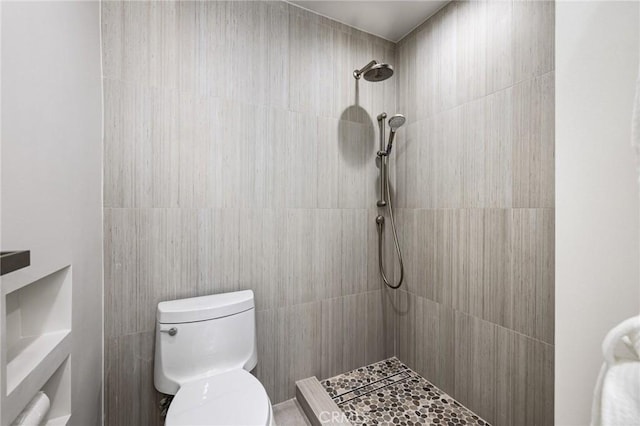 bathroom with toilet and a tile shower