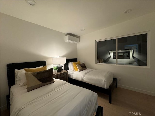 bedroom with hardwood / wood-style flooring and a wall mounted AC