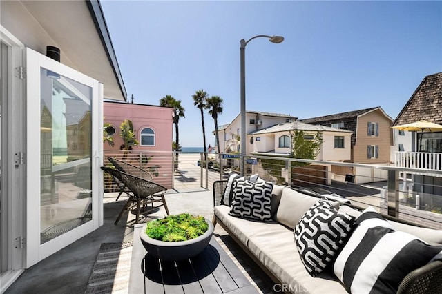 balcony with a water view and an outdoor hangout area