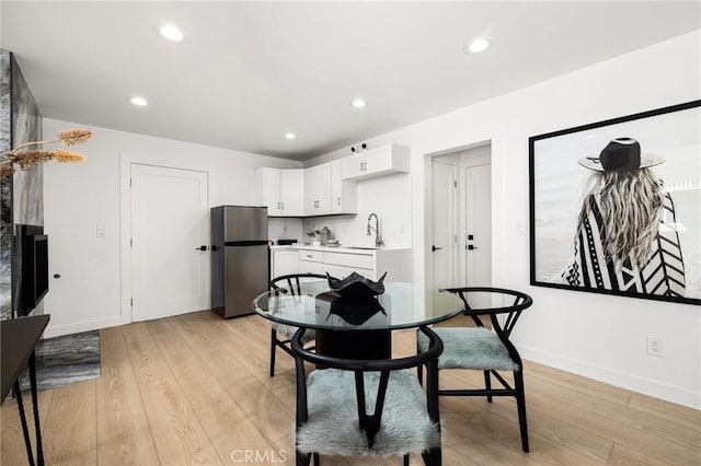 dining area featuring sink and light hardwood / wood-style floors