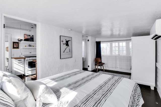 bedroom with a wall mounted air conditioner and dark wood-type flooring