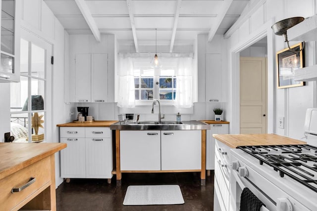 kitchen with wooden counters, sink, decorative light fixtures, white cabinets, and white gas stove