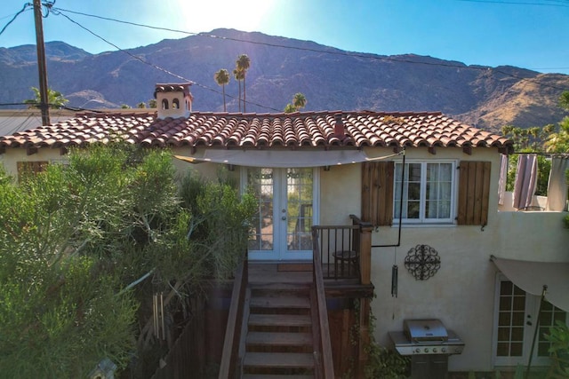 rear view of house featuring a mountain view and french doors