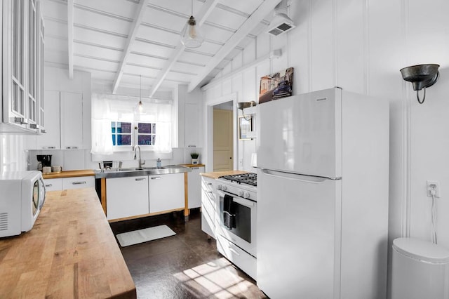 kitchen featuring sink, wood counters, lofted ceiling with beams, white appliances, and white cabinets