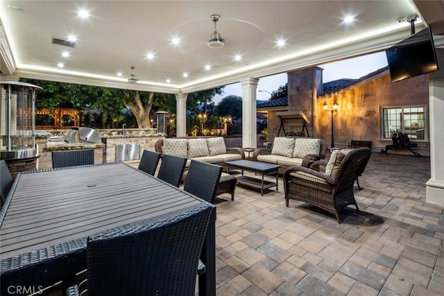 view of patio featuring outdoor lounge area, ceiling fan, a grill, and exterior kitchen