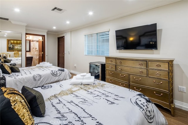 bedroom with wood-type flooring, connected bathroom, and crown molding