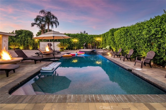 pool at dusk featuring a patio area