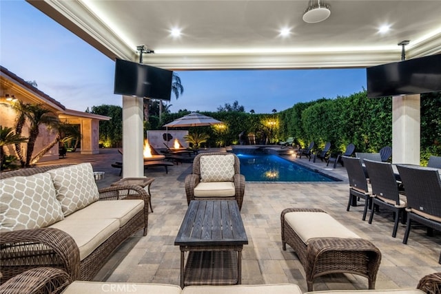 view of swimming pool with a patio and an outdoor living space with a fire pit