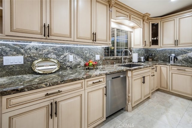 kitchen with dark stone countertops, dishwasher, sink, and decorative backsplash