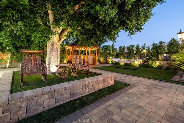 view of community with a lawn, a patio area, and a gazebo