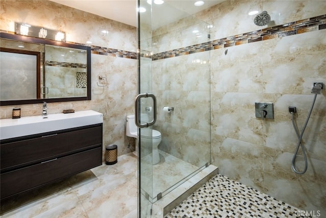 bathroom featuring tile walls, walk in shower, vanity, and toilet