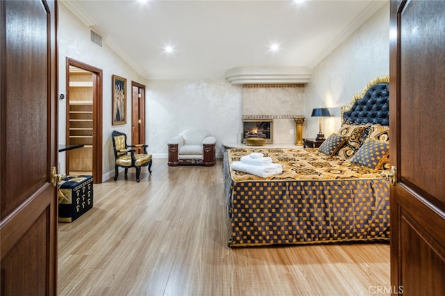 bedroom with ornamental molding and light hardwood / wood-style floors