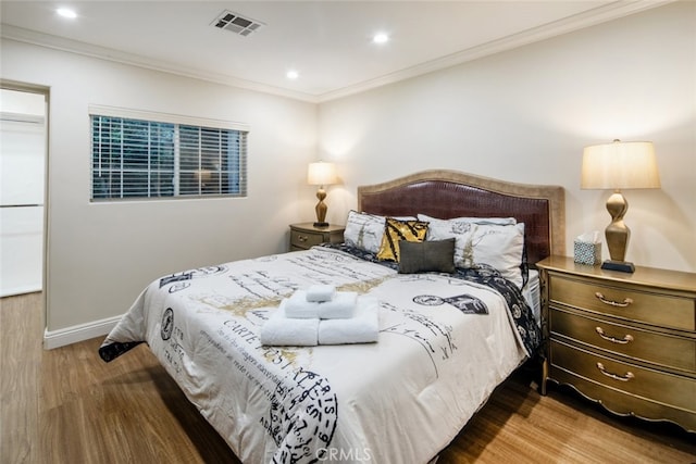 bedroom with ornamental molding and hardwood / wood-style flooring