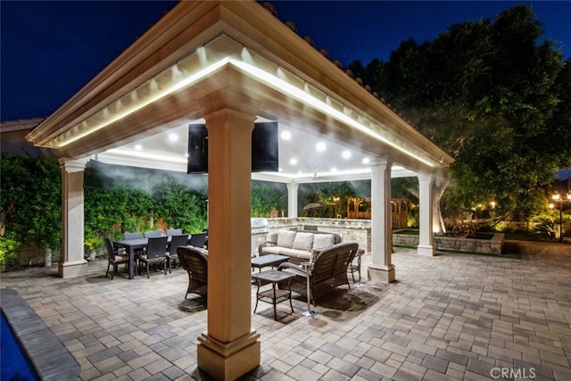 patio at night with an outdoor living space and a gazebo