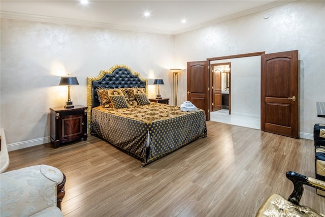 bedroom with ornamental molding and light hardwood / wood-style floors