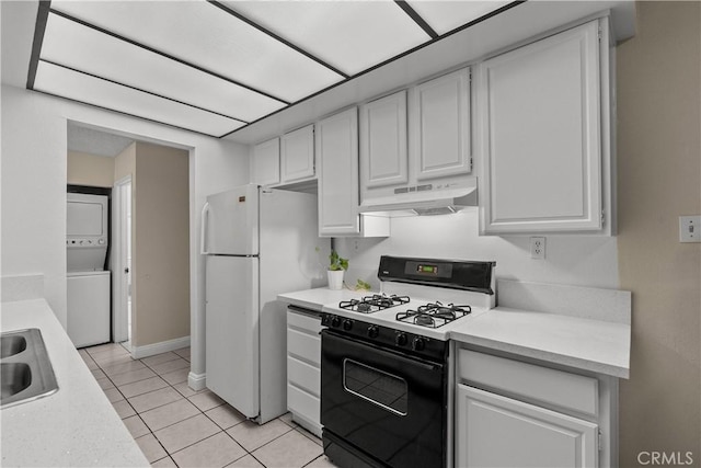 kitchen with white appliances, stacked washer and clothes dryer, white cabinets, sink, and light tile patterned flooring