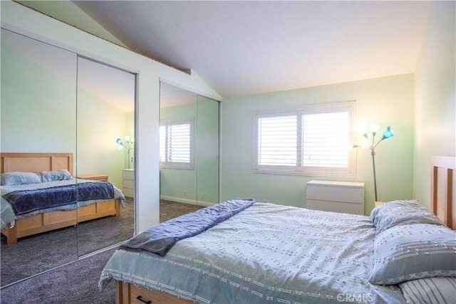 bedroom featuring multiple closets, lofted ceiling, and carpet
