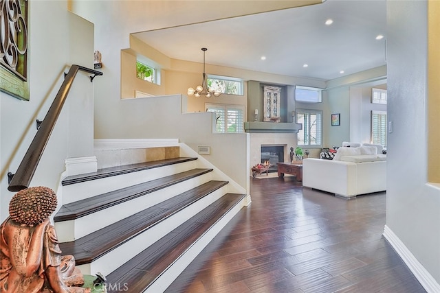 stairs featuring an inviting chandelier and wood-type flooring