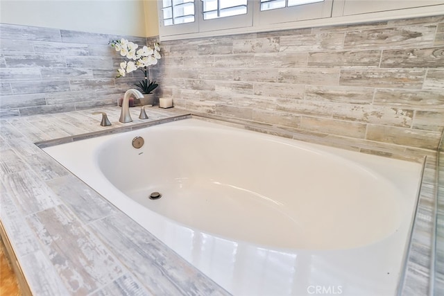 bathroom with hardwood / wood-style flooring and a bath