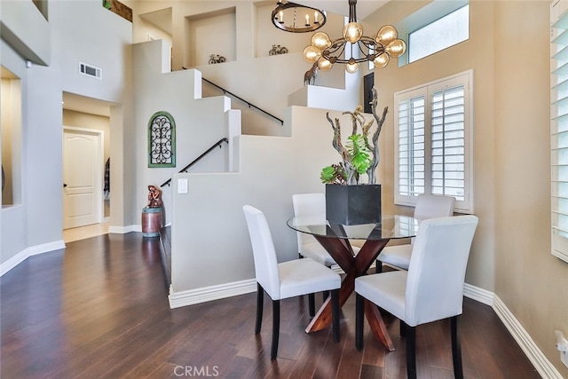 dining area featuring a high ceiling, a chandelier, and dark hardwood / wood-style floors