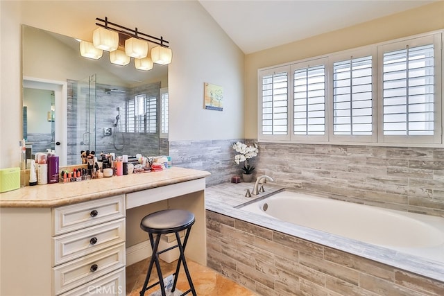 bathroom with a healthy amount of sunlight, shower with separate bathtub, vaulted ceiling, and vanity