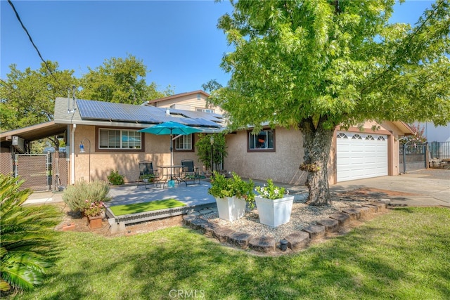 view of front of property featuring a front lawn, solar panels, and a garage