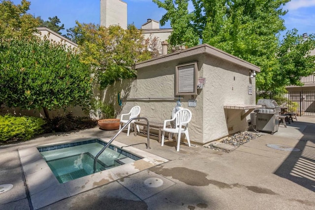 view of pool with a patio, a community hot tub, and grilling area