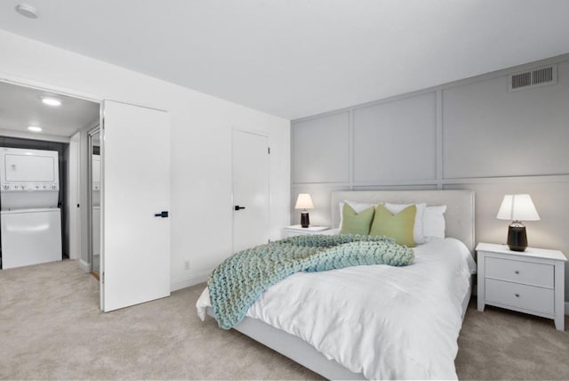 carpeted bedroom featuring stacked washer and dryer