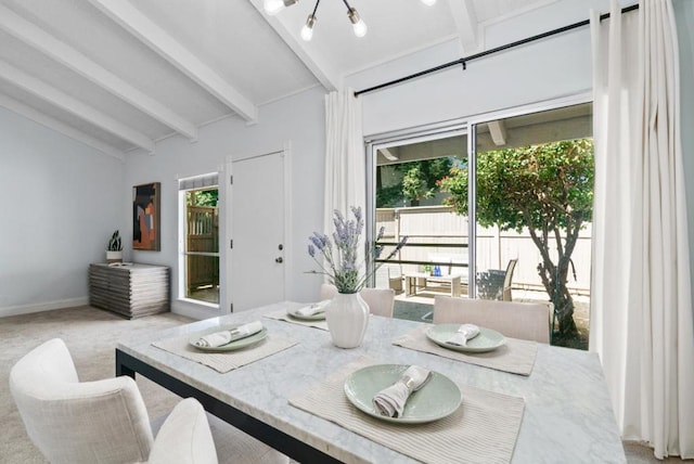 carpeted dining space featuring lofted ceiling with beams