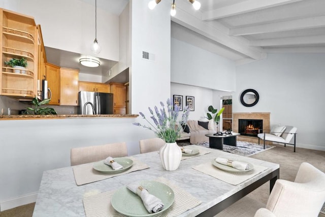 dining area with light colored carpet and lofted ceiling with beams