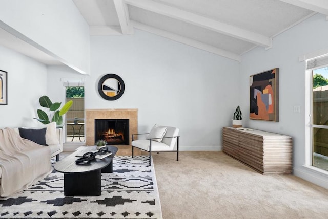 carpeted living room with lofted ceiling with beams and a high end fireplace