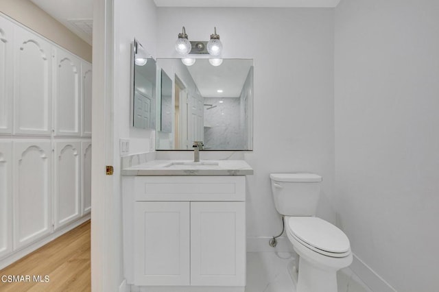 bathroom with hardwood / wood-style floors, vanity, toilet, and walk in shower