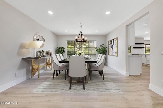 dining space featuring plenty of natural light, light hardwood / wood-style floors, and a chandelier