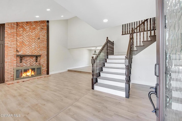 stairway with a fireplace and wood-type flooring