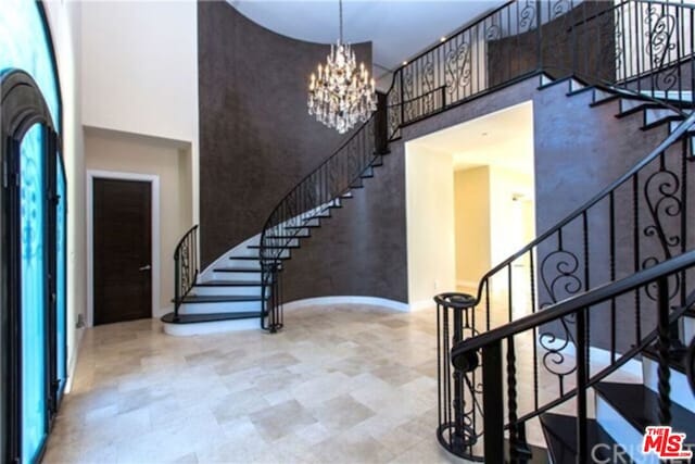 foyer with a towering ceiling and a notable chandelier