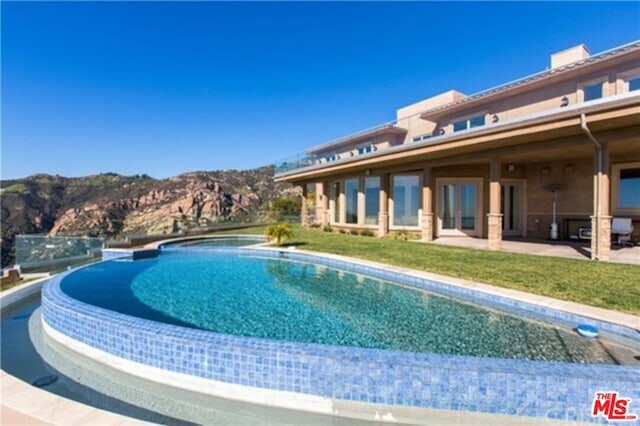 view of pool featuring a patio area and a mountain view